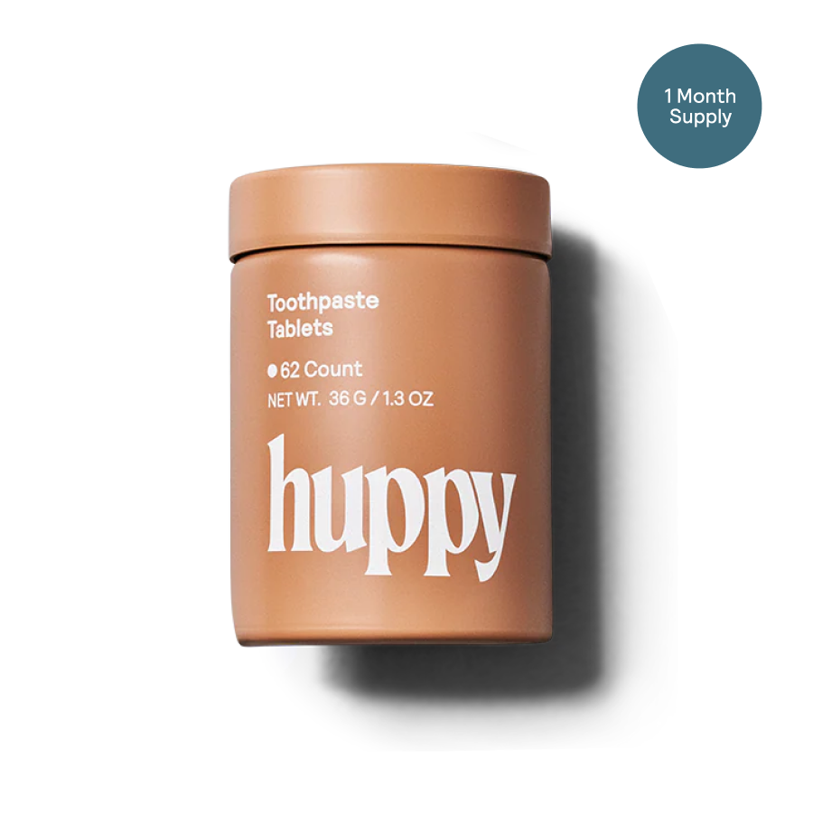 Container of huppy toothpaste tablets with a white background