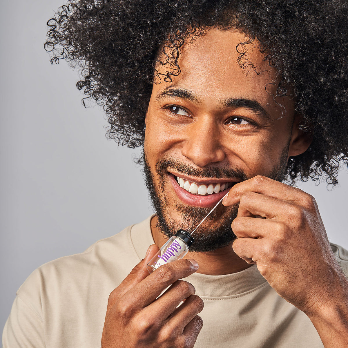 Man smiling while flossing with Huppy floss